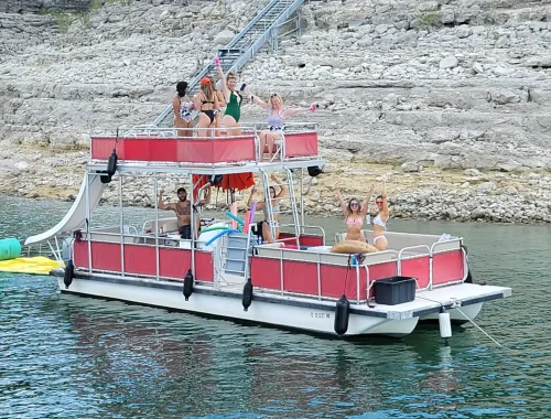 Double-decker party boat on lake travis with slide named Islander hosting a bachelorette party in Devils Cove.